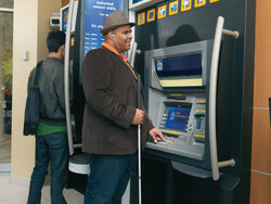 Man using accessible features of a bank machine.